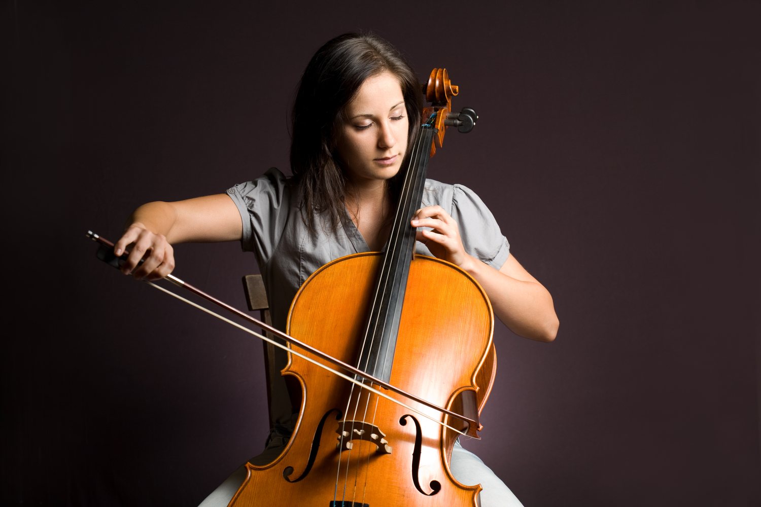 Cellistin spielt Cello in aufrechter Sitzposition